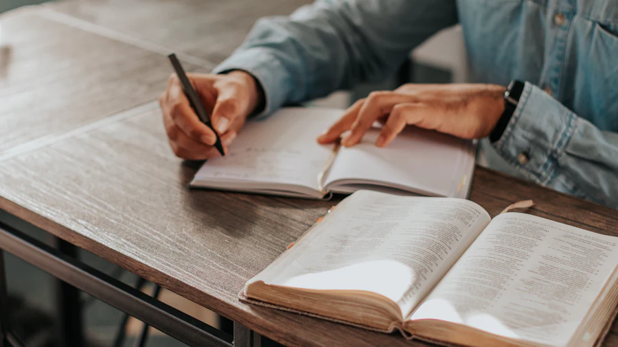 Manos escribiendo cuentas a mano en un cuaderno abierto