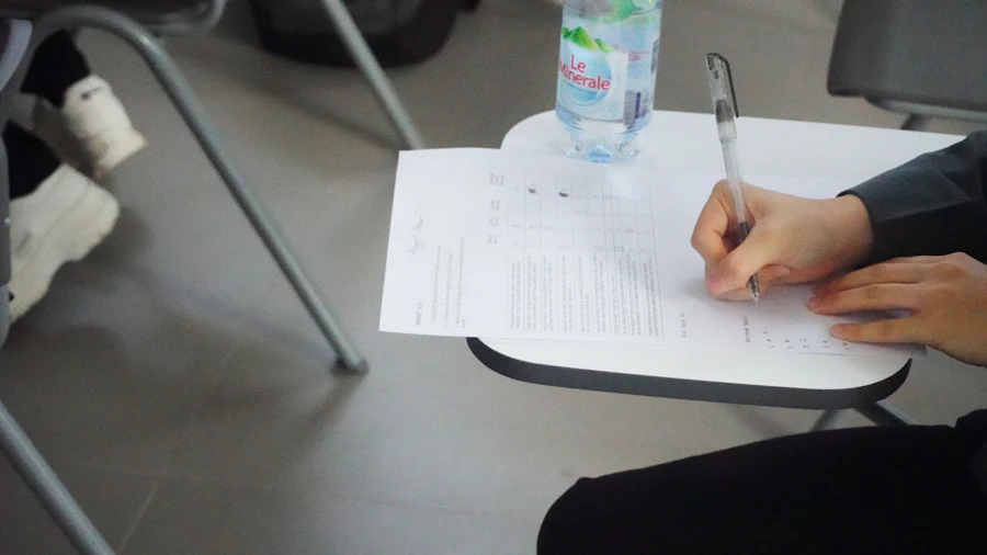 Estudiante diligenciando un formulario de respuestas sobre un pupitre
